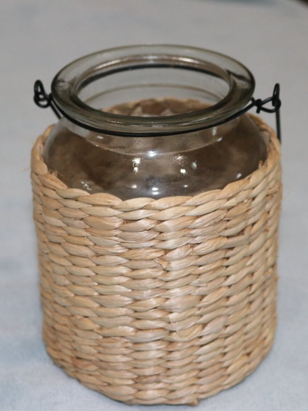 Glass and wicker flower vase with handle.
